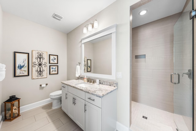 bathroom with tile patterned flooring, vanity, an enclosed shower, and toilet