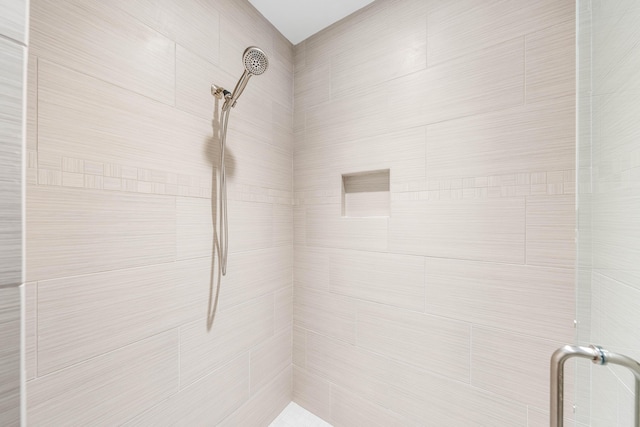 interior details with a shower with door