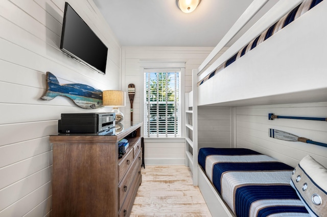 bedroom featuring wood walls