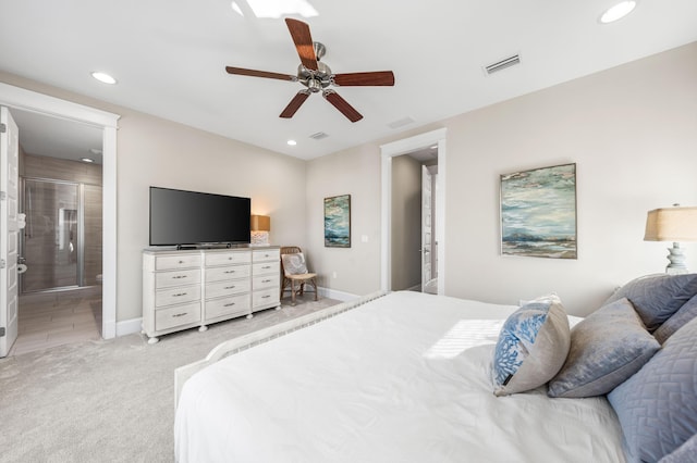 bedroom with connected bathroom, light carpet, and ceiling fan