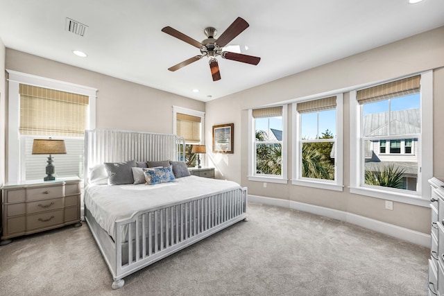 carpeted bedroom with multiple windows and ceiling fan