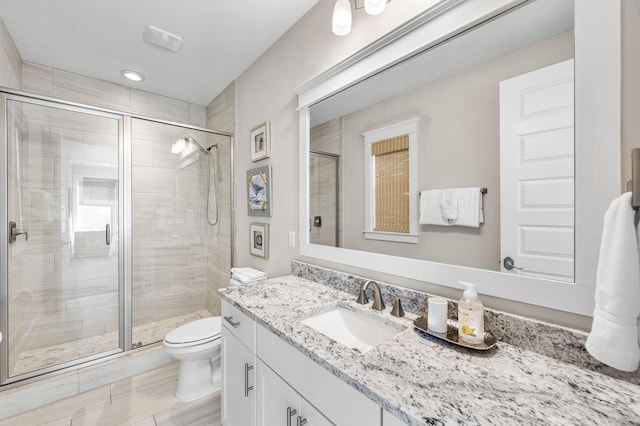 bathroom with vanity, toilet, and an enclosed shower