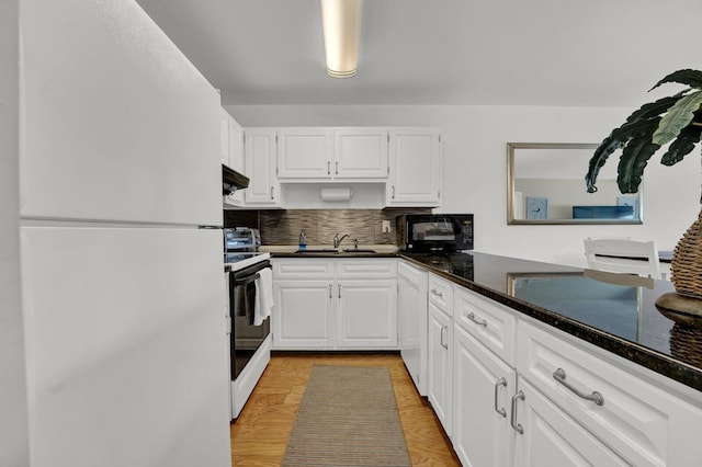 kitchen with white cabinetry, sink, white appliances, and dark stone counters