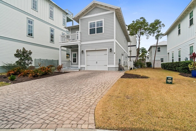 view of front of house with a front yard, decorative driveway, and an attached garage