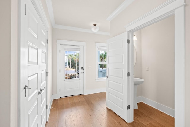 doorway to outside featuring wood-type flooring, ornamental molding, and baseboards