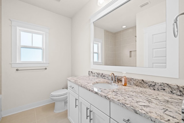 bathroom featuring baseboards, visible vents, tile patterned flooring, a tile shower, and vanity