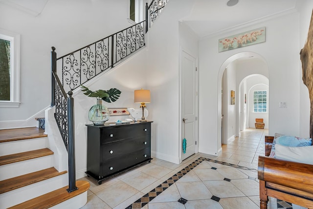 tiled foyer featuring ornamental molding