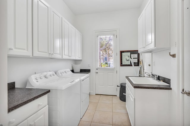 clothes washing area with light tile patterned flooring, cabinets, sink, and washing machine and clothes dryer