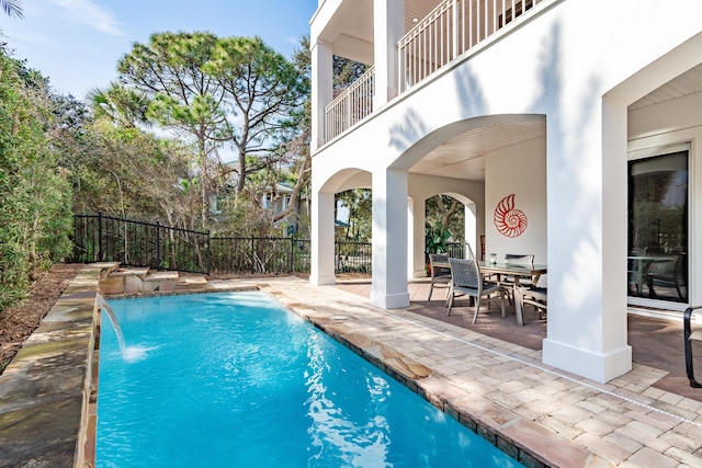 view of swimming pool with pool water feature and a patio area