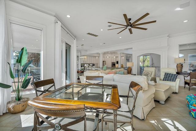 tiled living room featuring decorative columns, crown molding, and ceiling fan