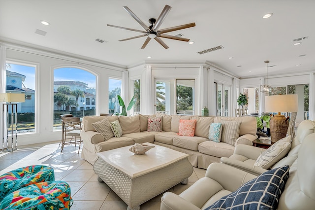 living room with light tile patterned flooring, plenty of natural light, and crown molding