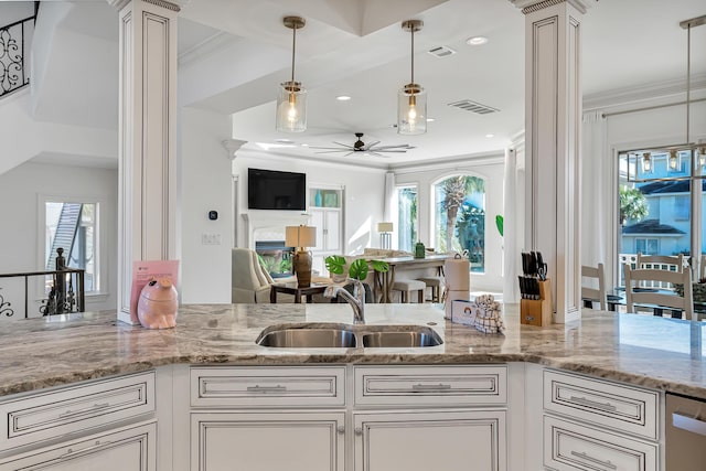 kitchen featuring pendant lighting, decorative columns, sink, crown molding, and a healthy amount of sunlight