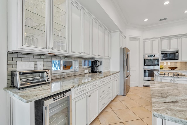 kitchen with black appliances, beverage cooler, and white cabinets