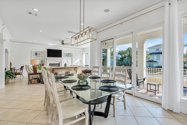 tiled dining area with crown molding and ceiling fan