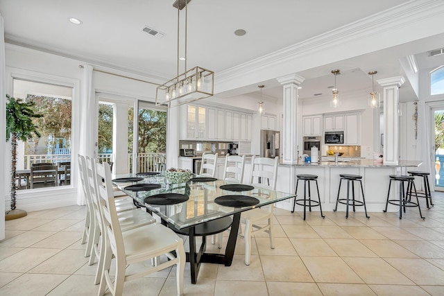 tiled dining space with ornamental molding and ornate columns