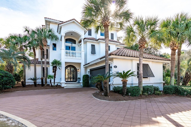 mediterranean / spanish home featuring a balcony and a garage