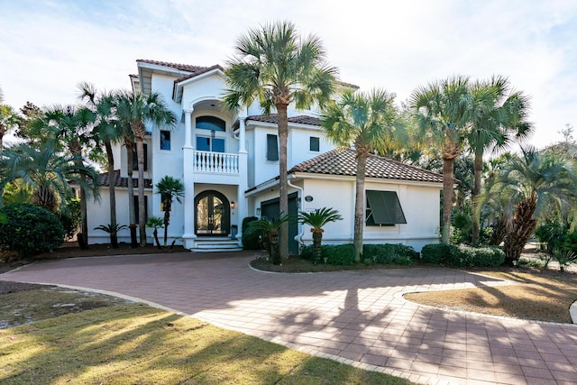 mediterranean / spanish home with a balcony and a front yard