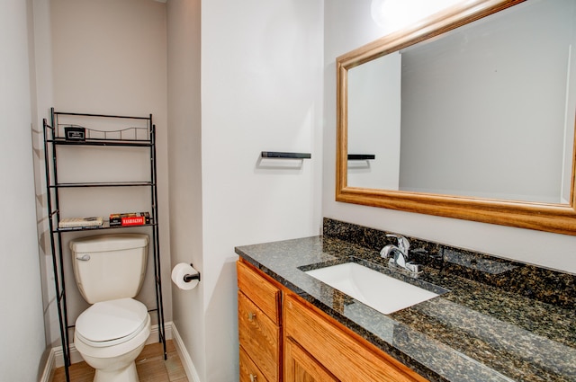 bathroom featuring vanity, toilet, and baseboards