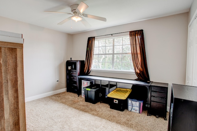 carpeted home office with baseboards and a ceiling fan