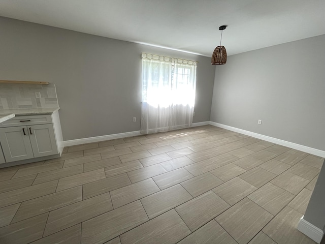 unfurnished dining area featuring baseboards