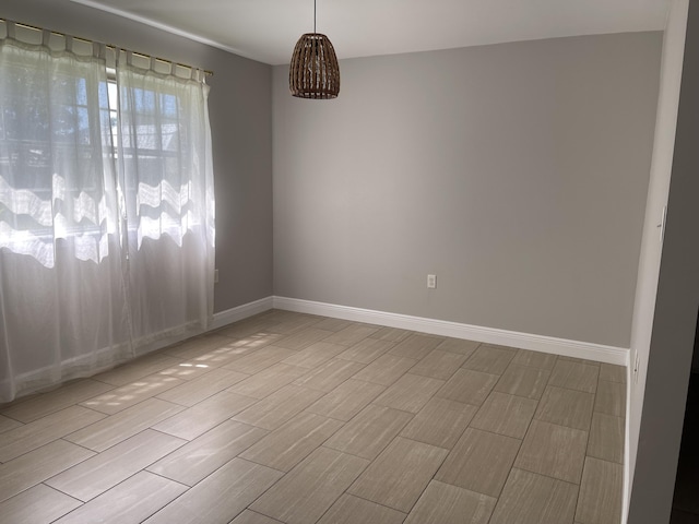 empty room featuring baseboards and wood tiled floor