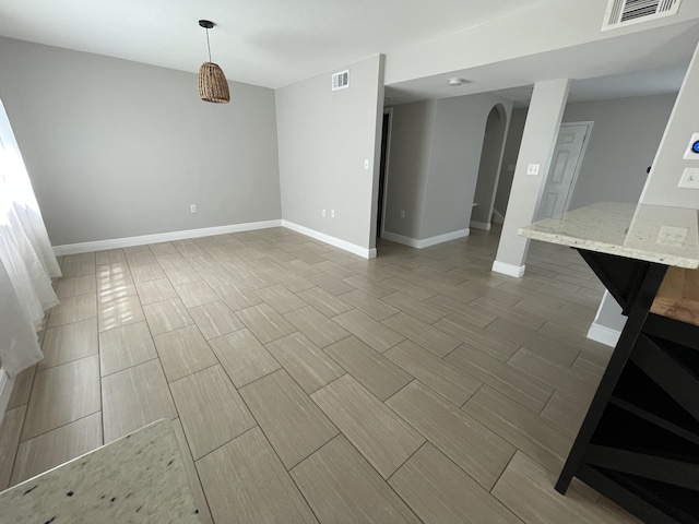 unfurnished room featuring arched walkways, visible vents, and wood tiled floor