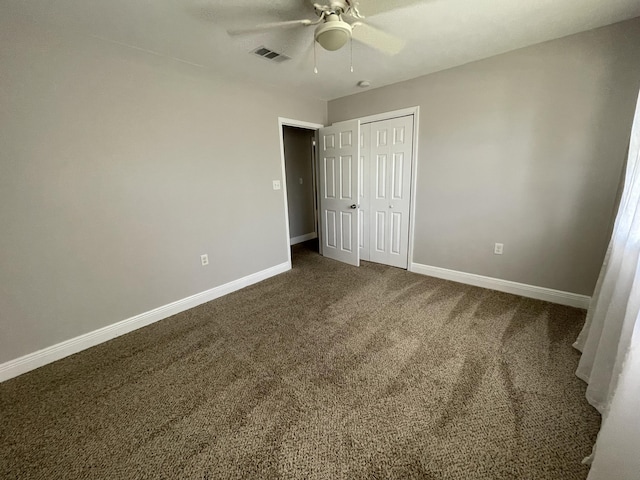 unfurnished bedroom with a closet, baseboards, visible vents, and dark colored carpet