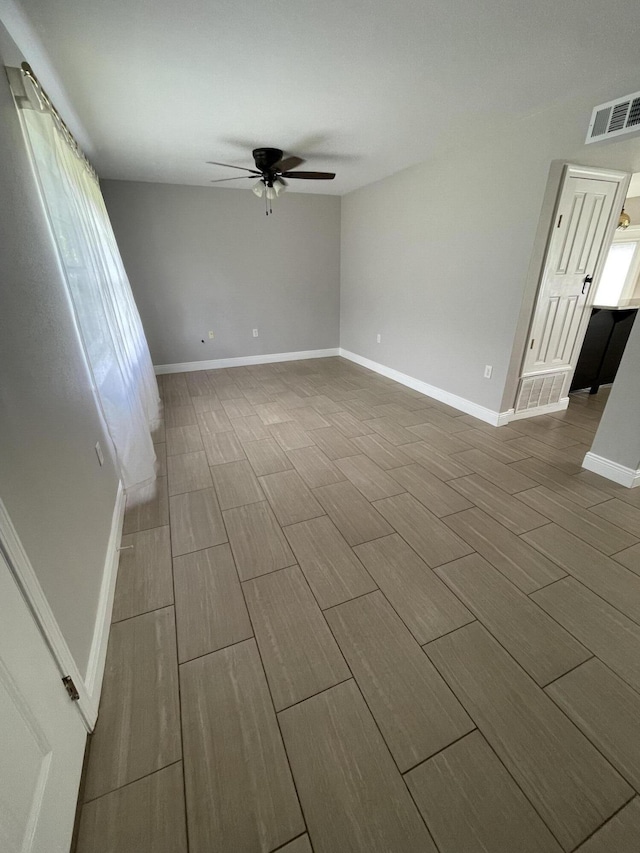 unfurnished room with visible vents, baseboards, ceiling fan, and wood tiled floor