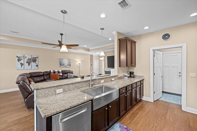 kitchen featuring visible vents, light wood-style flooring, stainless steel dishwasher, a sink, and a peninsula