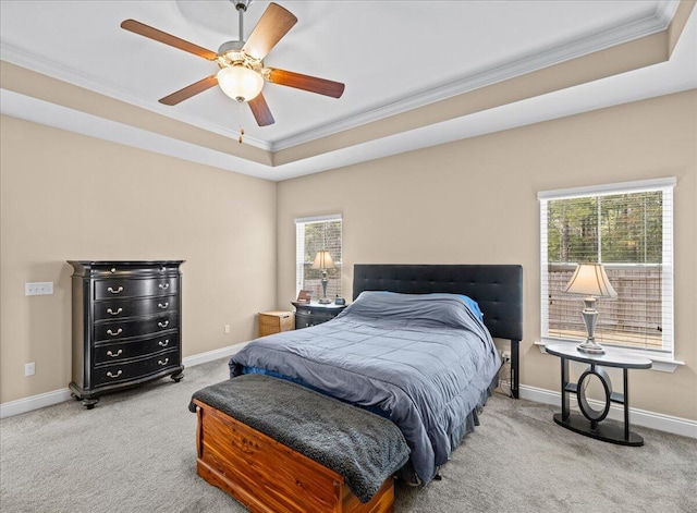 bedroom with crown molding, light colored carpet, a raised ceiling, and ceiling fan