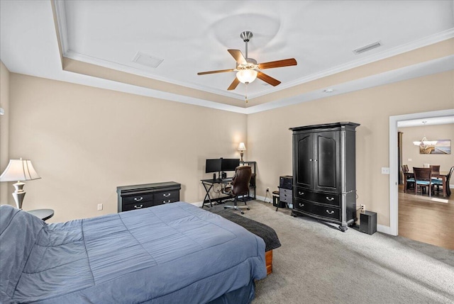 carpeted bedroom featuring ornamental molding, a raised ceiling, and ceiling fan with notable chandelier