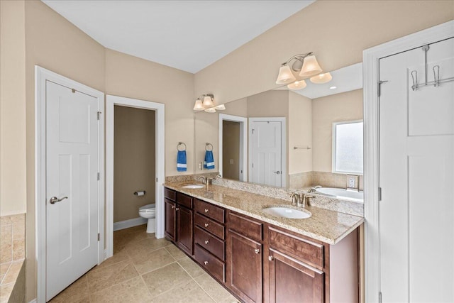 full bathroom with toilet, tile patterned flooring, double vanity, and a sink