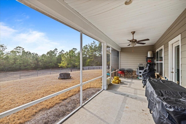 unfurnished sunroom with ceiling fan