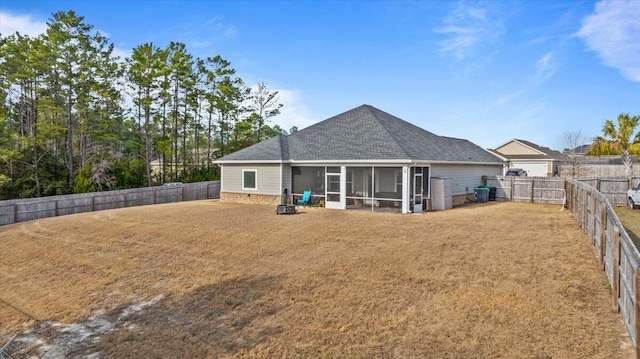 back of house with a sunroom, a fenced backyard, and a lawn