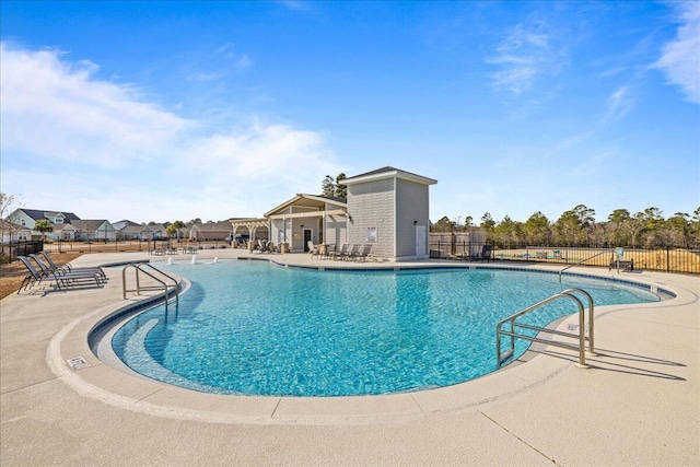 pool with a patio and fence