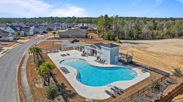 pool with a patio, fence, and a residential view