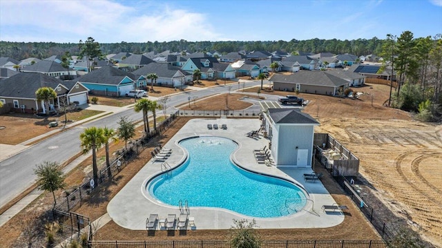 pool with a residential view, a patio area, and fence