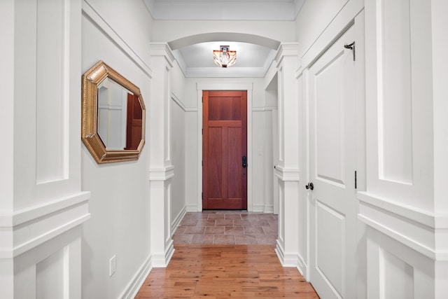 doorway to outside with crown molding and light wood-type flooring