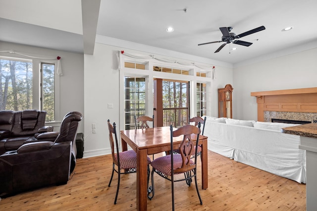 dining space featuring a wealth of natural light, ornamental molding, and light wood-type flooring