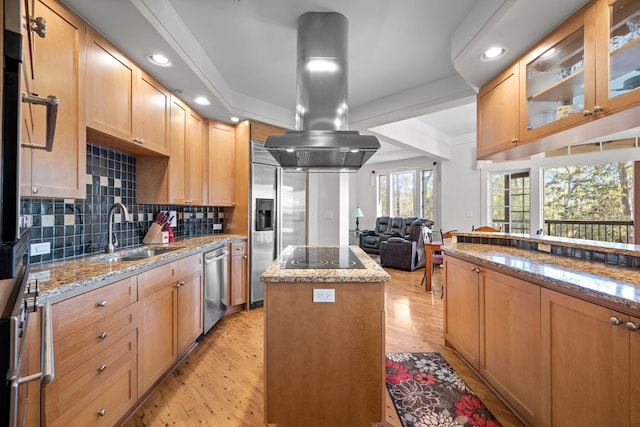 kitchen with sink, island exhaust hood, a center island, light stone countertops, and black electric cooktop