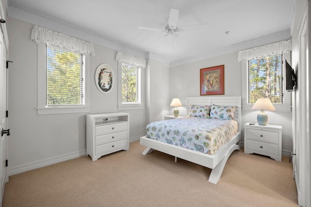 carpeted bedroom featuring crown molding and ceiling fan
