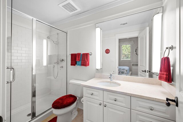 bathroom featuring vanity, a shower with door, and toilet