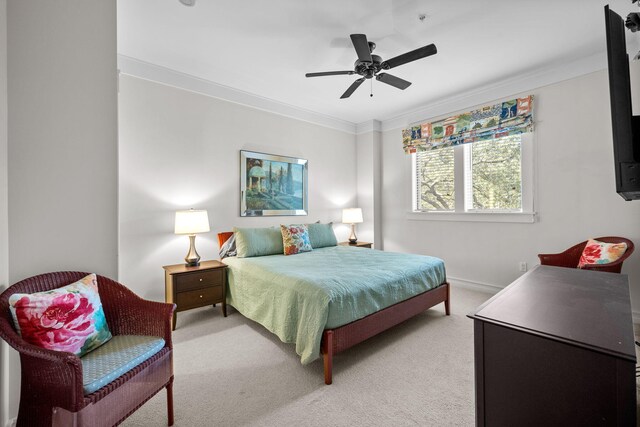 carpeted bedroom featuring crown molding and ceiling fan