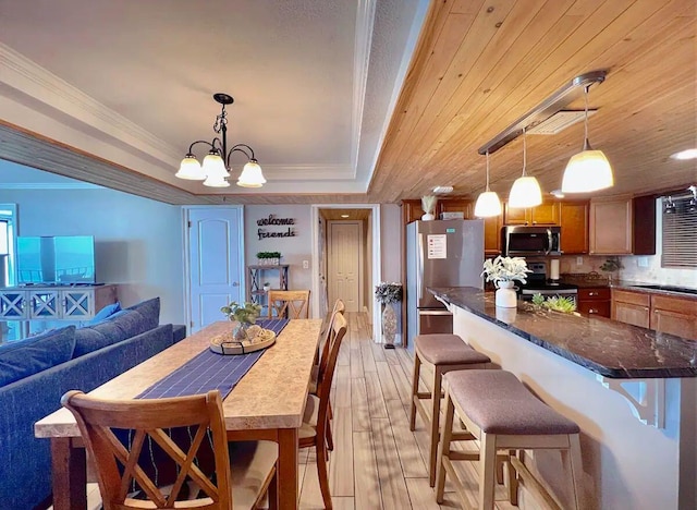 dining space with wood ceiling, crown molding, a raised ceiling, a chandelier, and light wood-type flooring