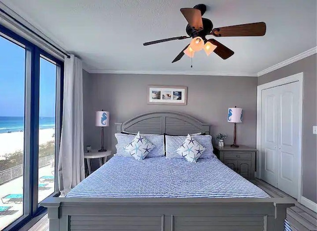 bedroom featuring ornamental molding, access to outside, ceiling fan, a water view, and light hardwood / wood-style flooring