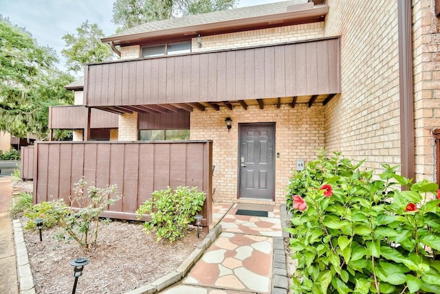 view of exterior entry with a balcony