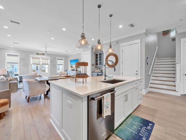 kitchen featuring sink, white cabinetry, hanging light fixtures, dishwasher, and an island with sink