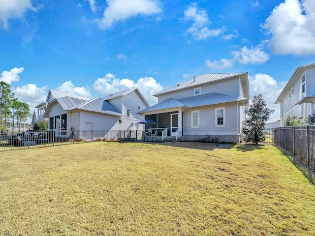 back of house with a yard and a sunroom