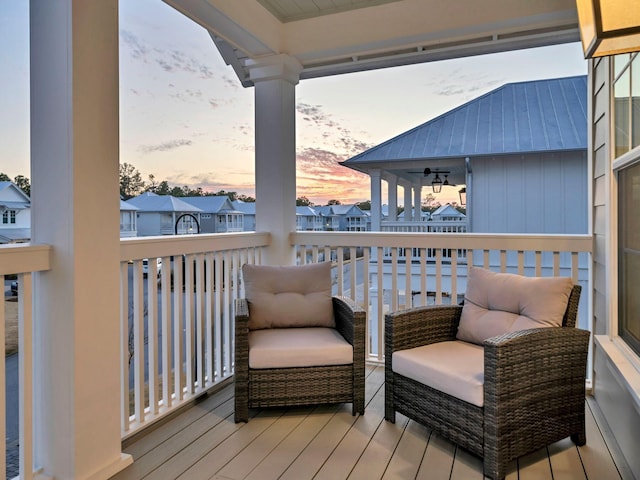 balcony at dusk featuring ceiling fan