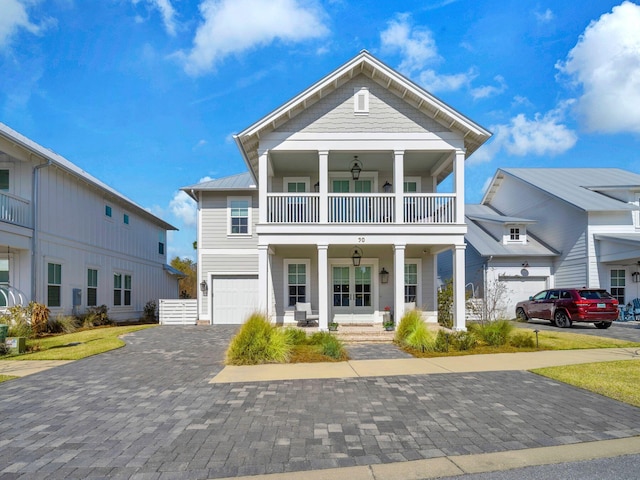 view of front of property featuring a garage, a balcony, and covered porch